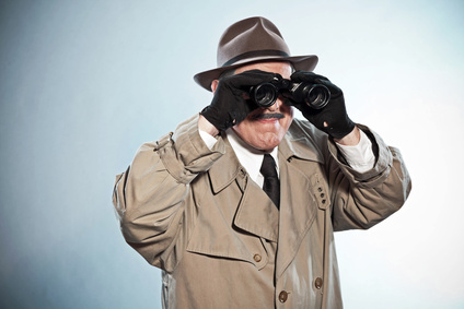 Vintage detective with mustache and hat. Looking through binoculars